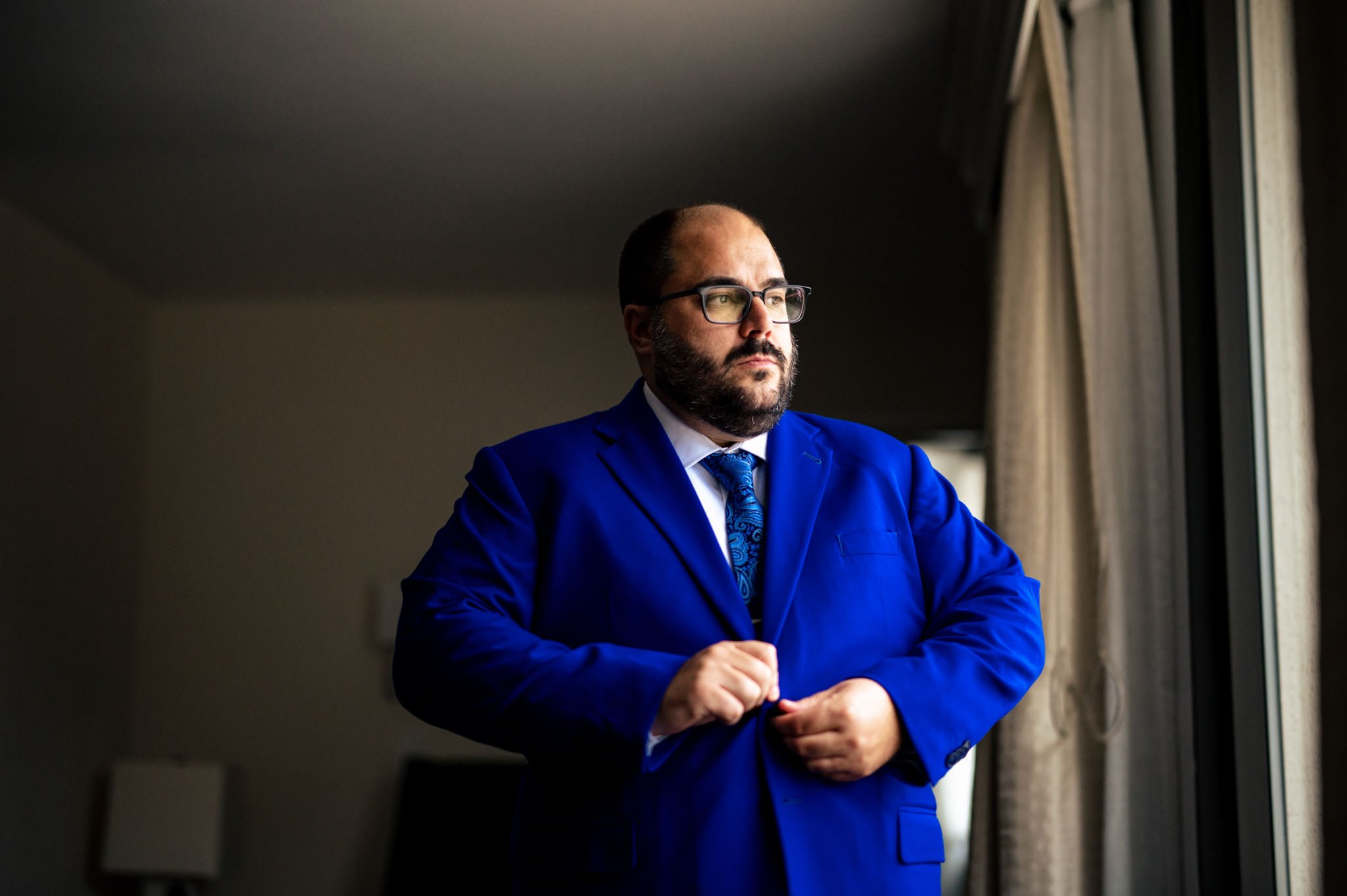 A man in a blue suit at a wedding photographed in Raleigh, NC.