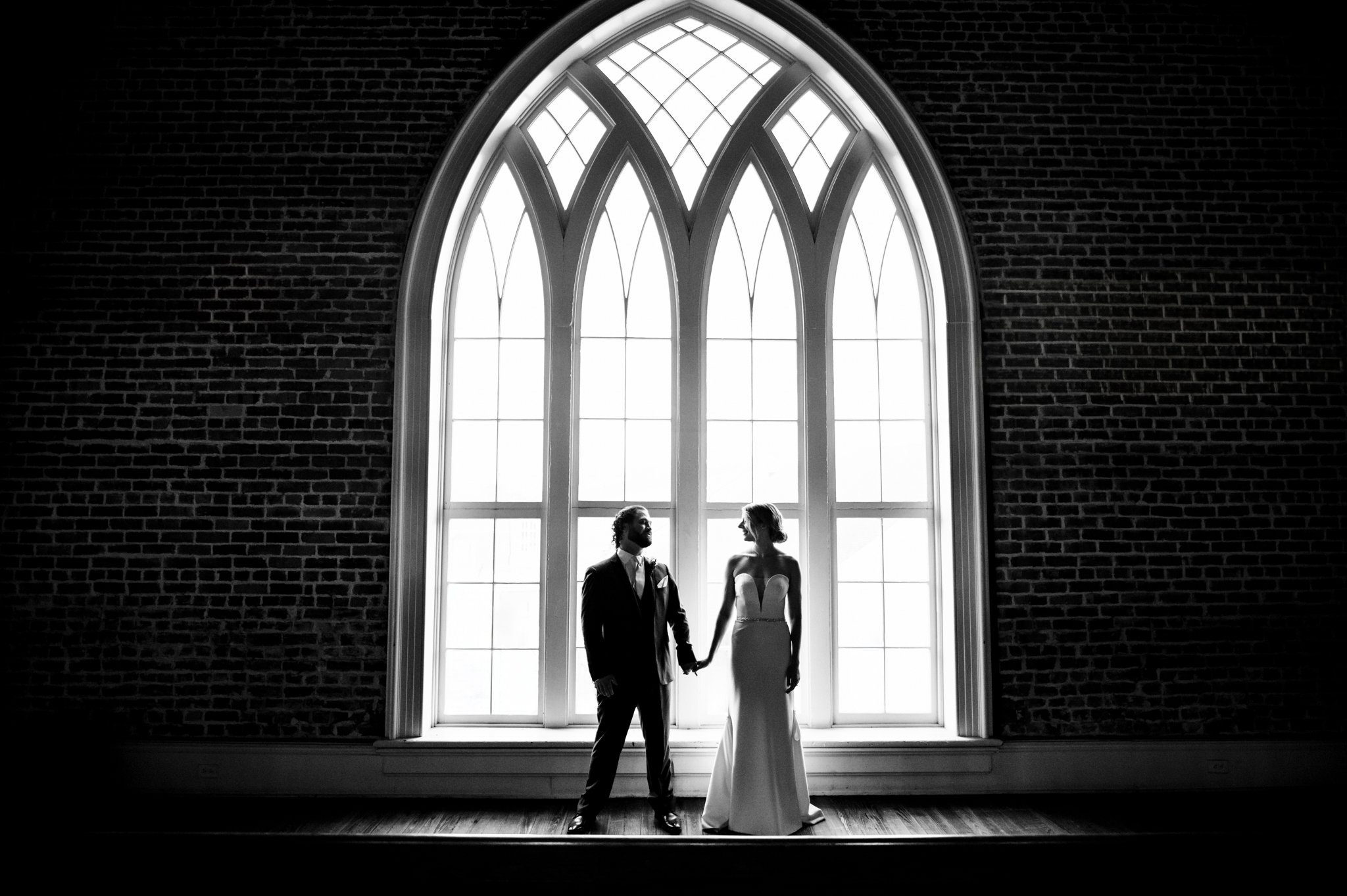 A bride and groom standing in front of a window at their felicity church wedding in New Orleans.
