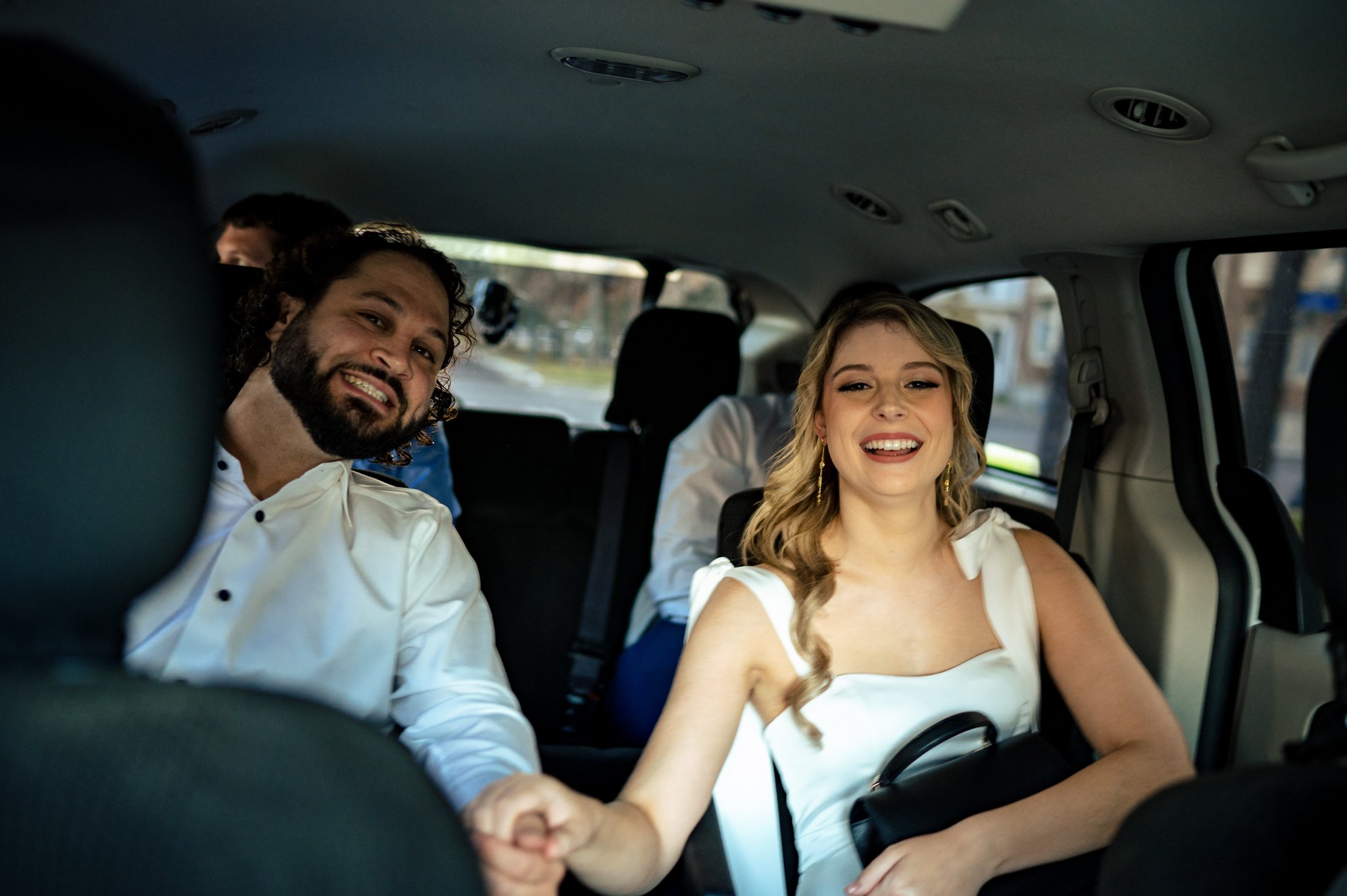 Smiling bride and groom in the back seat of a car at a Felicity Church wedding in New Orleans.