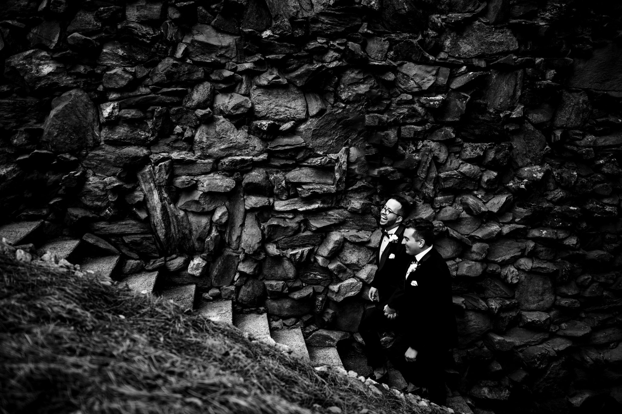 Two men standing on the steps of the Seely Pavilion, part of a stone wall at Grove Park Inn.