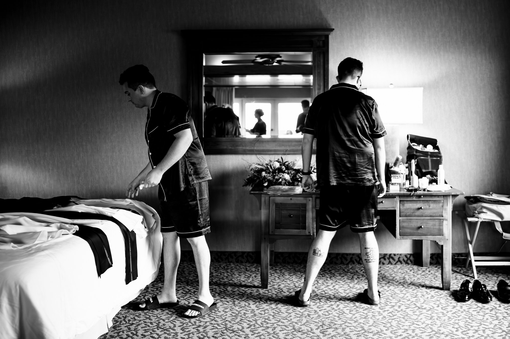 Two men in wedding attire standing in front of a mirror at the Grove Park Inn's Seely Pavilion.