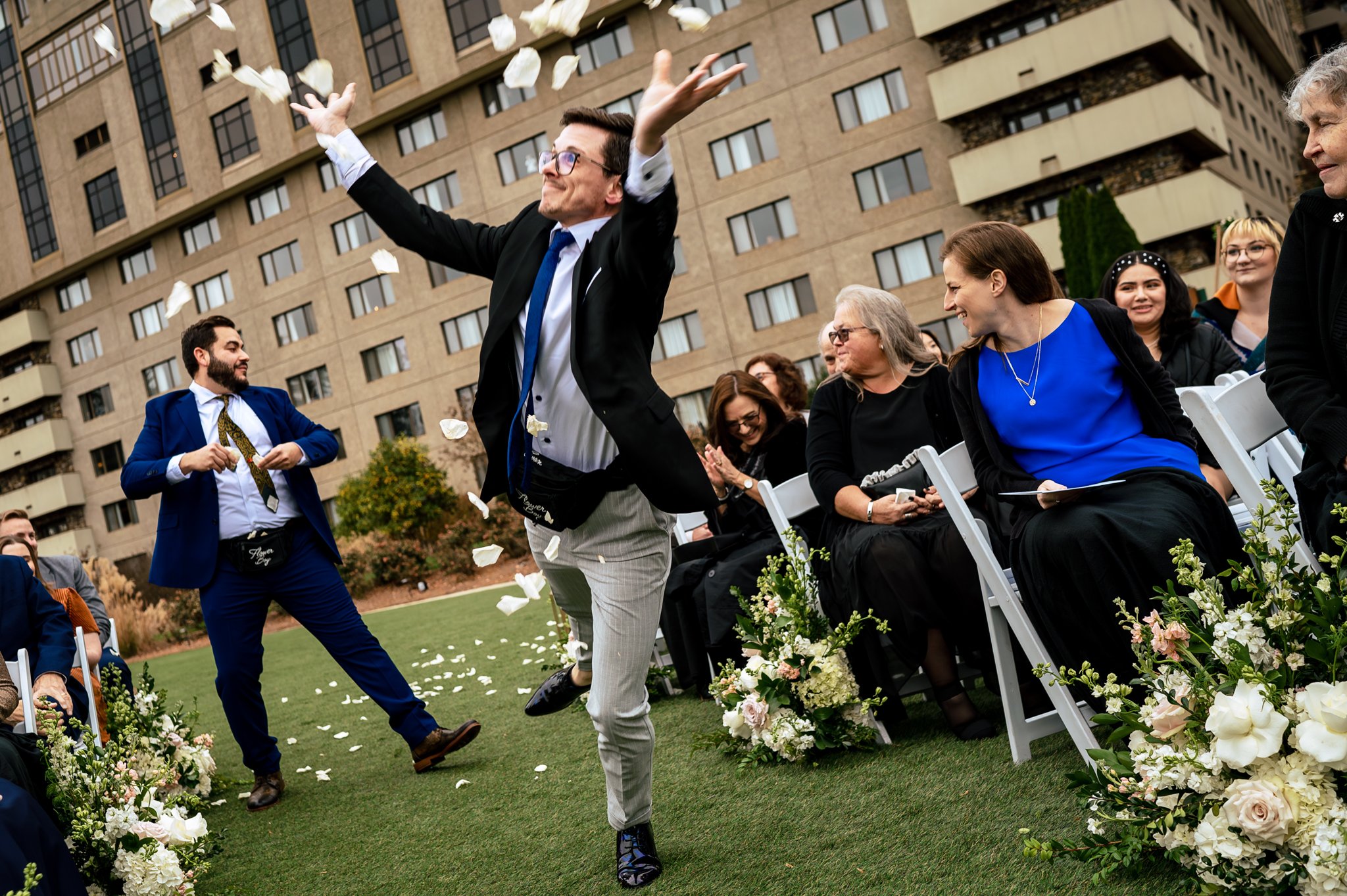 A man capturing joyful moments with his photography portfolio, throwing confetti at a wedding ceremony.