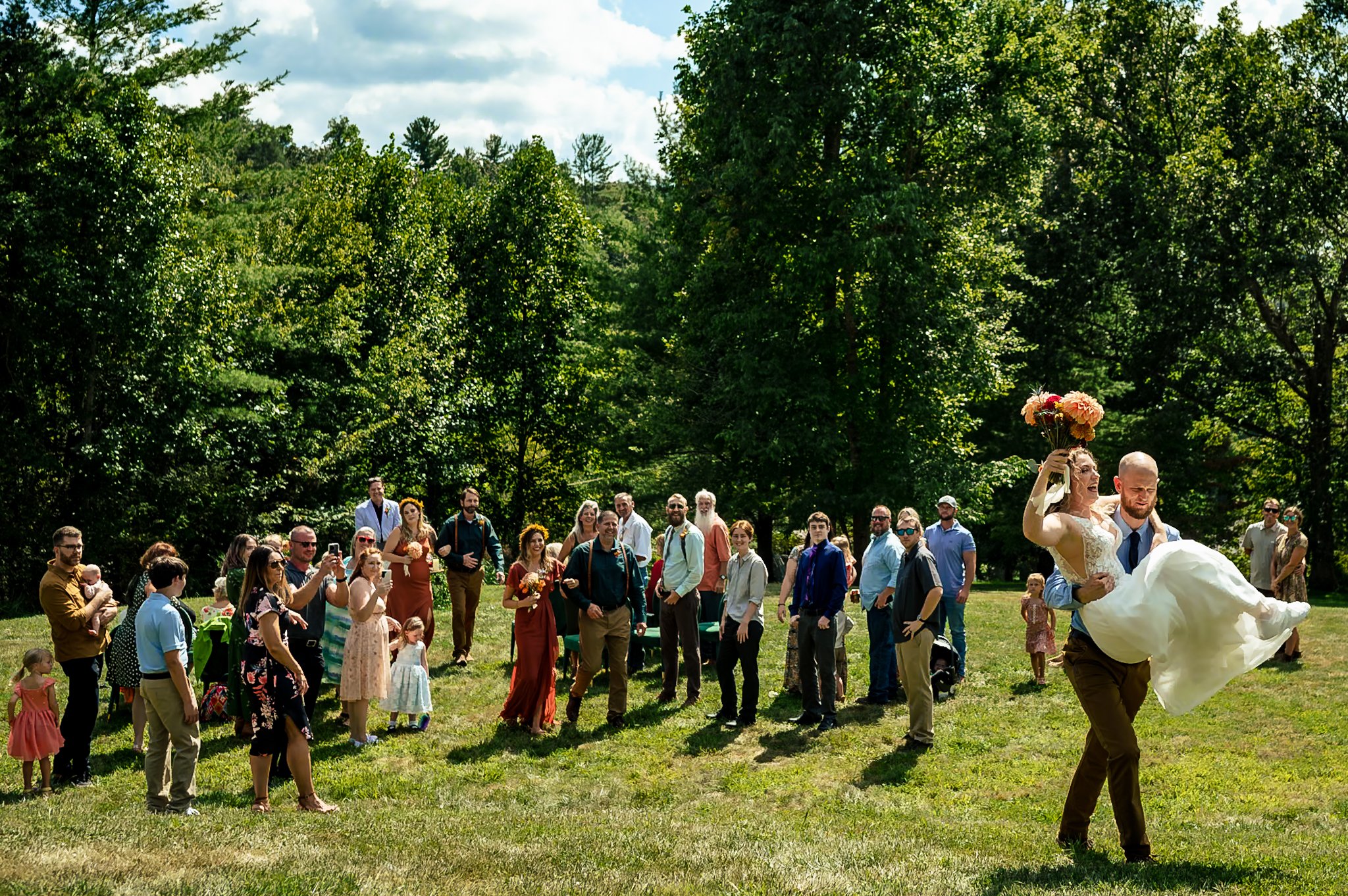 A wedding photography portfolio capturing a bride and groom in the air during a woodland celebration.
