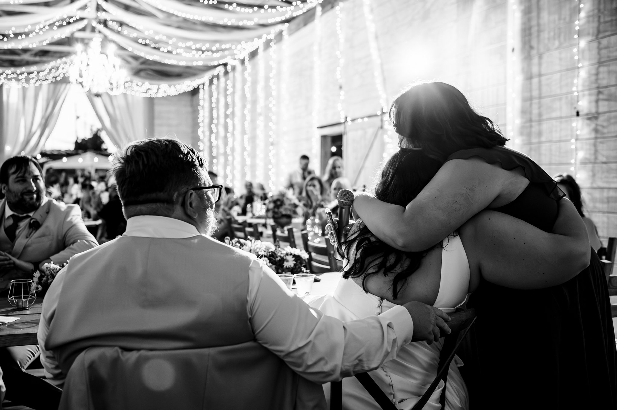 A bride and groom hugging at a wedding reception captured in photography.