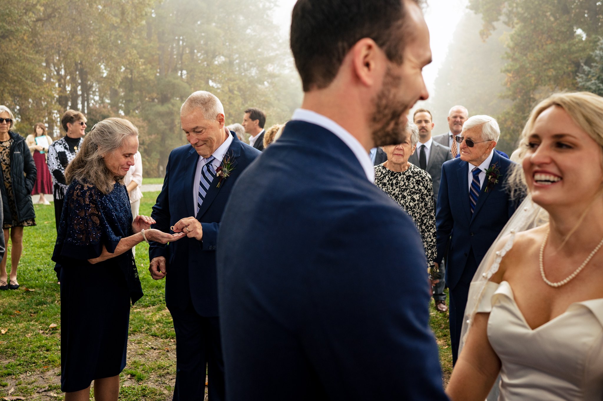 A bride and groom in Greensboro, North Carolina exchange their vows at their wedding ceremony, while a wedding photographer captures the special moments.