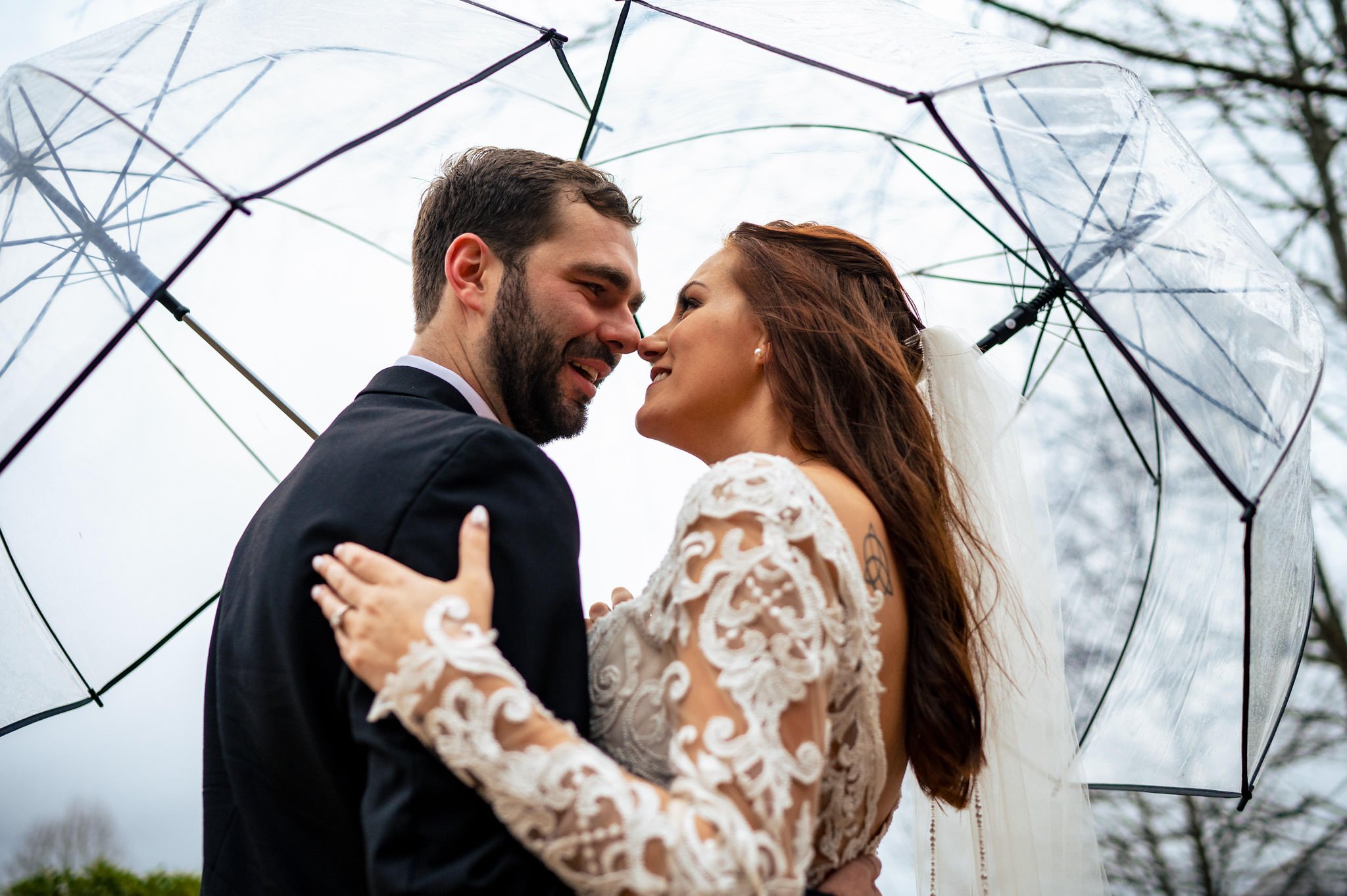 A bride and groom kiss under an umbrella at a wedding in Asheville, NC.