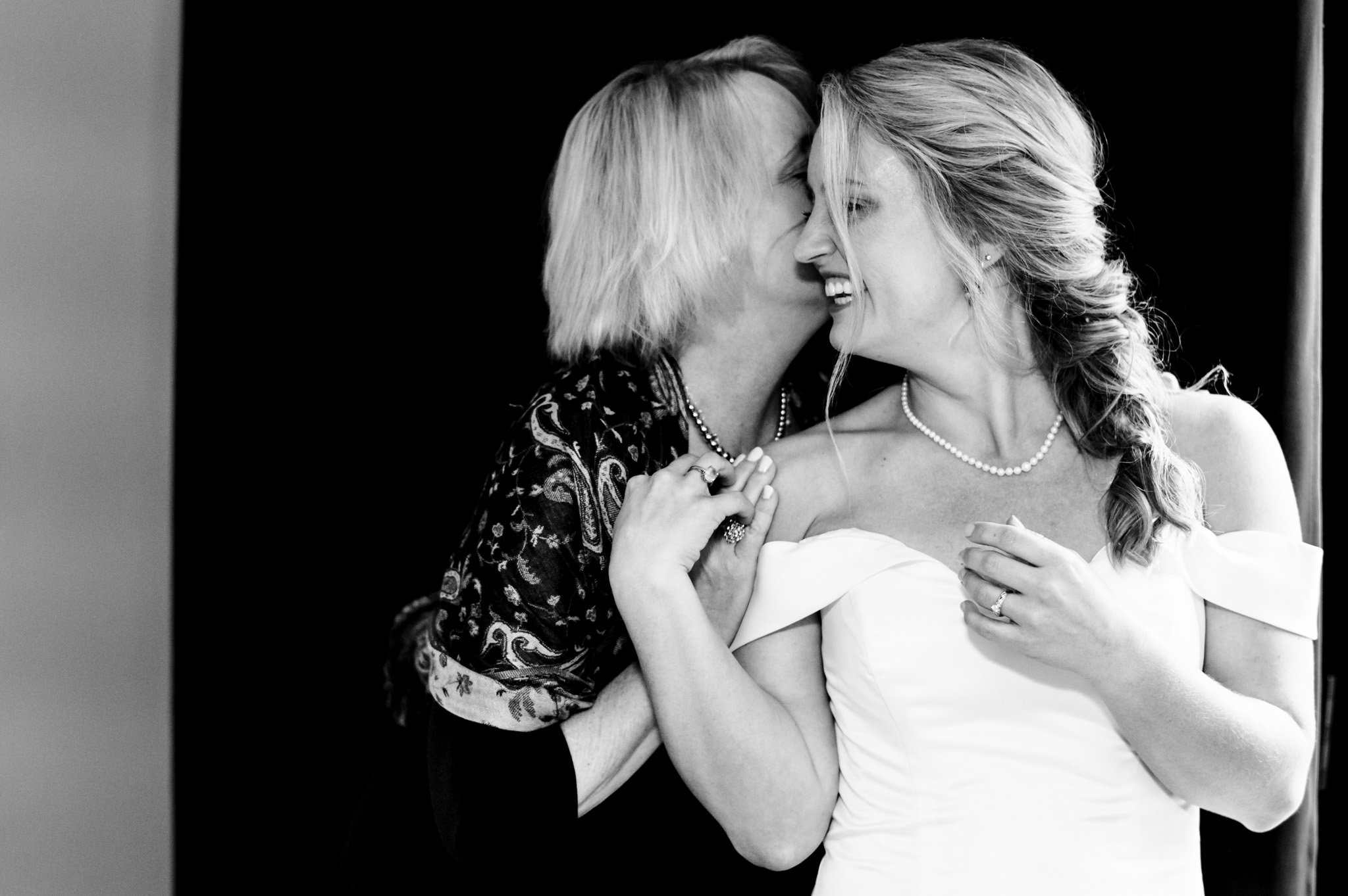 An emotional black and white photo capturing the heartfelt embrace between a bride and her mother at an Asheville wedding.