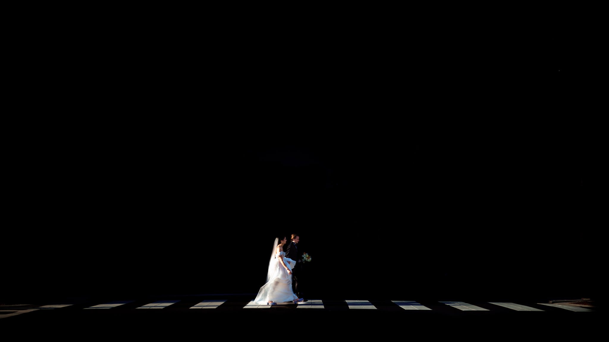 A bride and groom standing on a crosswalk in the dark after their micro wedding in Asheville.