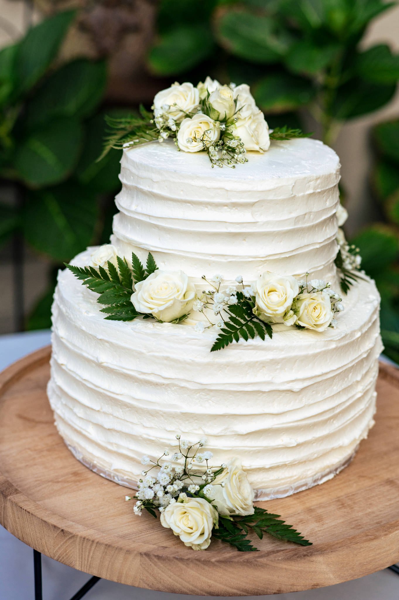 A white wedding cake with white flowers on top in an Asheville micro wedding.