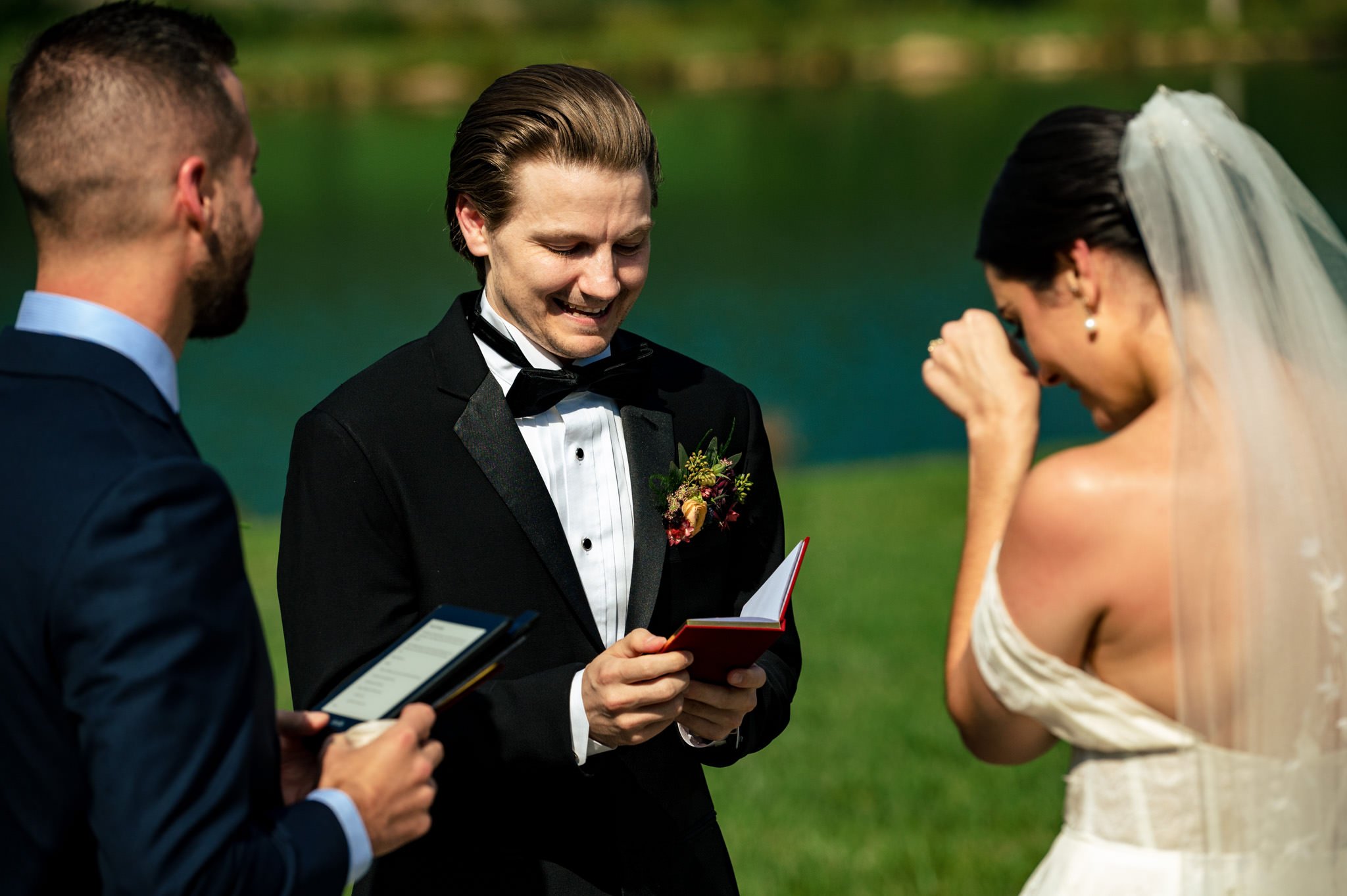 A bride and groom exchanging their wedding vows in front of an asheville lake.