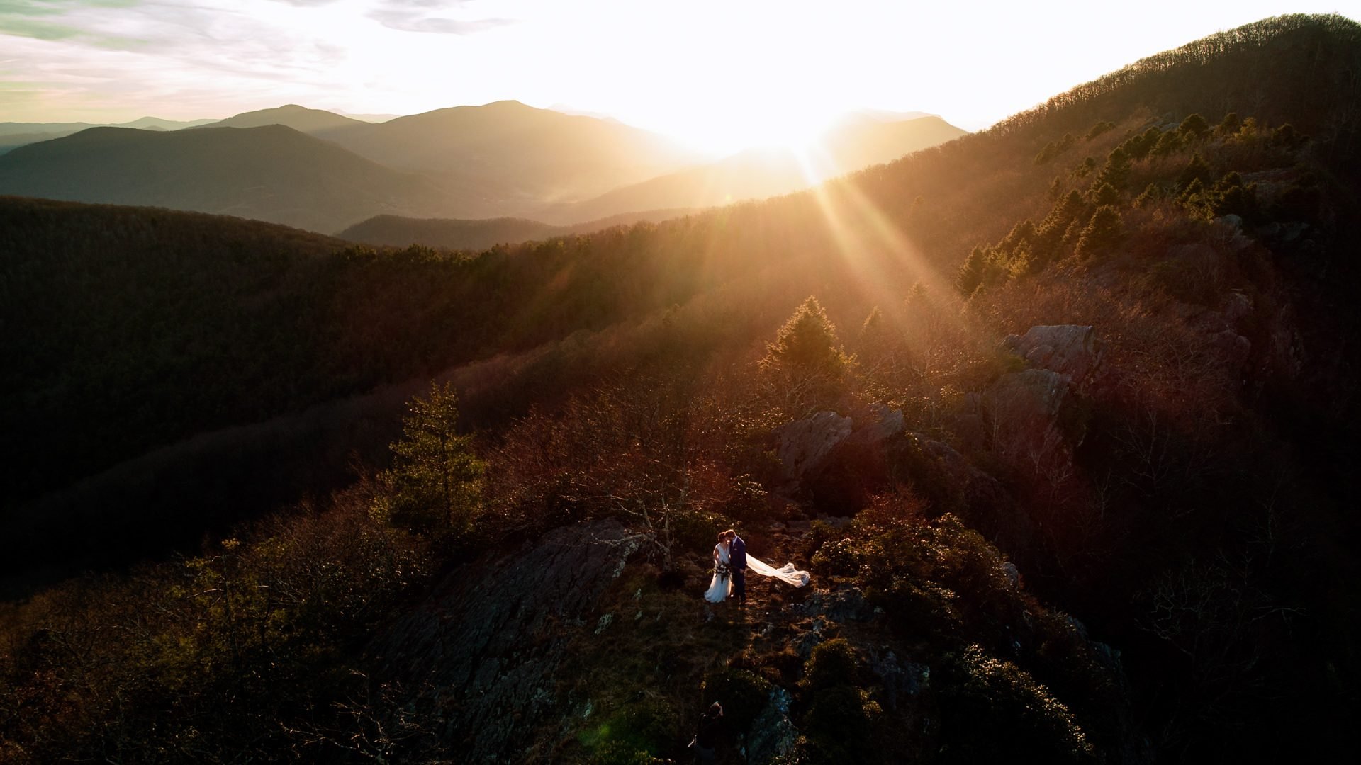 aerial photo of bride and groom in mountains